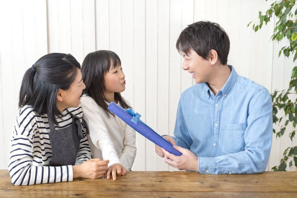 父の日に娘からのプレゼントをもらう父親